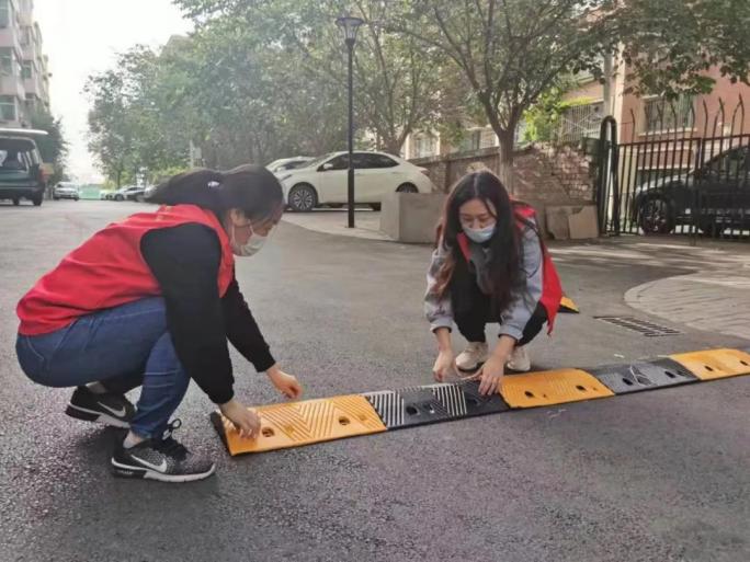 六道湾街道德裕社区组织在职党员干部对辖区坡度较大和急拐弯的路段安装减速带